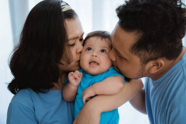 Asiático pequeño niño sonríe cuando besado por padre y madre —  Fotos de Stock