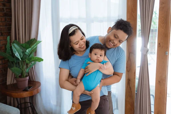 Asiático familia vistiendo azul camisa con bromeando a poco hijo —  Fotos de Stock