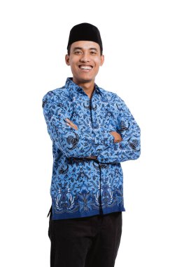 Gülümseyen genç adam ellerini çapraz tutan batik korpri giyiyor.