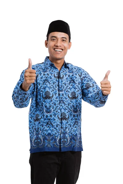 Asiatisk ung mann med batik korpri med to hender tommelen opp – stockfoto