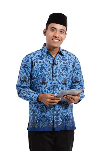 Asiatique jeune homme portant batik korpri en utilisant tablette numérique — Photo