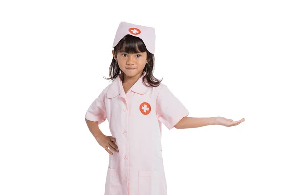 Little girl wearing a nurse uniform with one hand gestures giving things — Stock Photo, Image