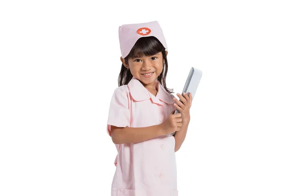 Усміхнена маленька медсестра в уніформі з тримає планшет цифровий — стокове фото