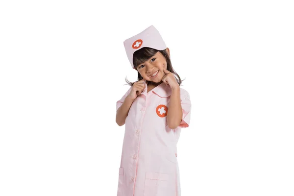 Asian little girl wearing a nurse uniform with hand holding her cheeks — Stock Photo, Image