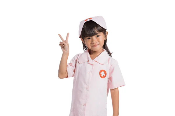 Petite infirmière souriante portant un uniforme avec ses mains mouvement numéro deux — Photo