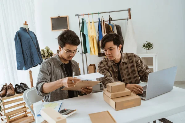 Δύο νεαροί ασιάτες επιχειρηματίες συζητούν για το προϊόν τους — Φωτογραφία Αρχείου