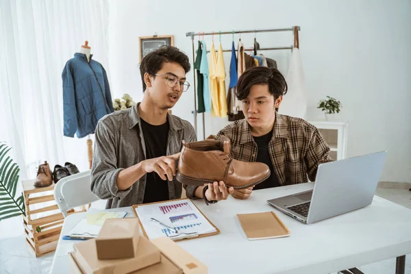 Δύο νεαροί ασιάτες επιχειρηματίες συζητούν για το προϊόν τους — Φωτογραφία Αρχείου