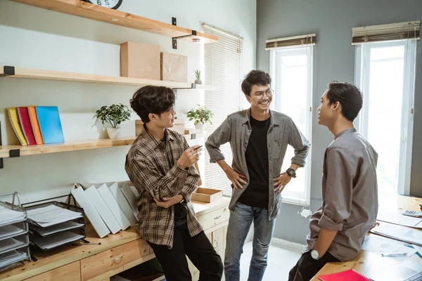 Tre giovane asiatico businessman chat circa il loro prodotto — Foto Stock