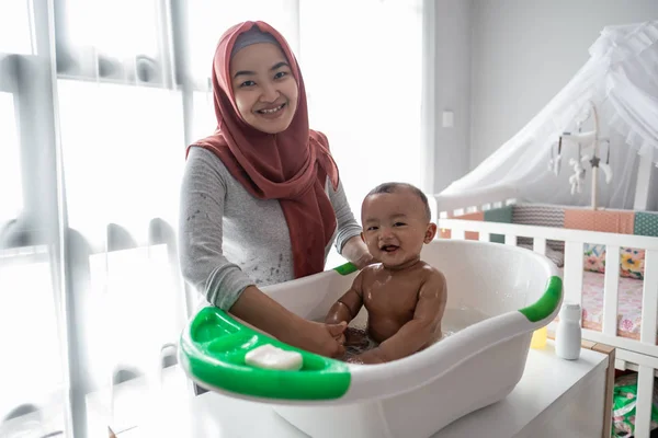 Muslim Ibu mencuci anak kecil di bak mandi — Stok Foto