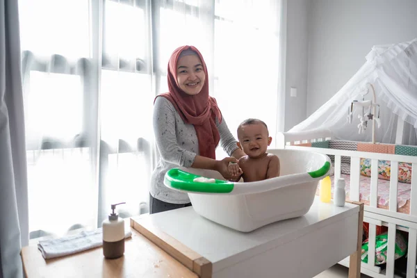 Muslim Ibu mencuci anak kecil di bak mandi — Stok Foto