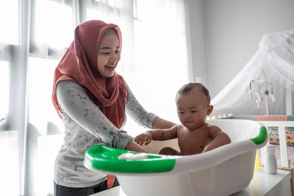 Muslim Ibu mencuci anak kecil di bak mandi — Stok Foto