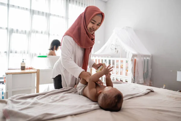 Ibu mengoleskan minyak bayi untuk bayinya — Stok Foto