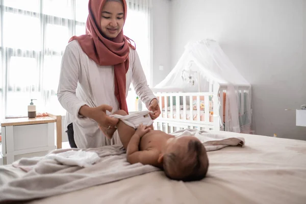 Ibu muslim mengganti popok bayi laki-lakinya — Stok Foto