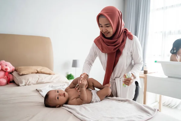 Muslim mother giving massage to her baby — 스톡 사진
