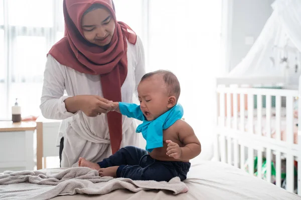 Asiatisk mamma byter sina babykläder — Stockfoto