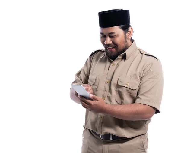 Pracovník s hnědou uniformou indonésie s úsměvem pomocí telefonu — Stock fotografie
