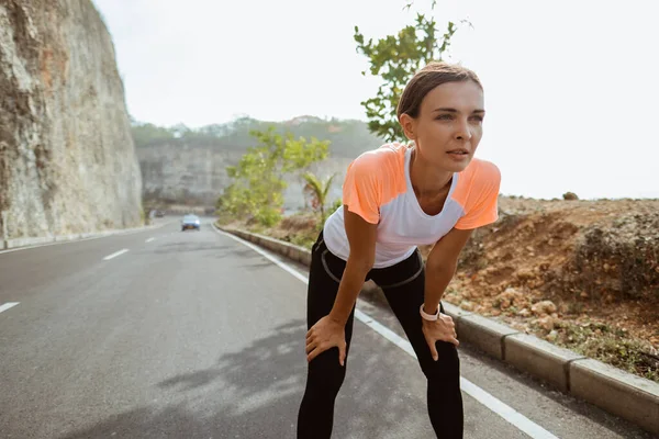 Attraktive Läuferin legt nach Joggen im Freien eine Pause ein — Stockfoto