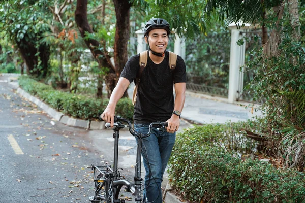 मुस्कुराते एशियाई युवा आदमी तह बाइक के साथ चल रहा है — स्टॉक फ़ोटो, इमेज