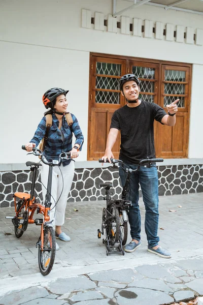 Asiáticos jóvenes parejas preparan bicicletas plegables y usan cascos antes de salir — Foto de Stock