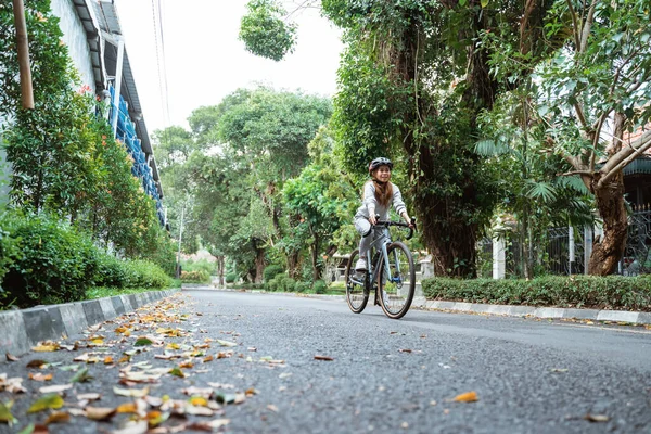Mulheres jovens andando de bicicleta na estrada — Fotografia de Stock