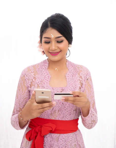 Ung kvinna som innehar kreditkort och använder telefon — Stockfoto