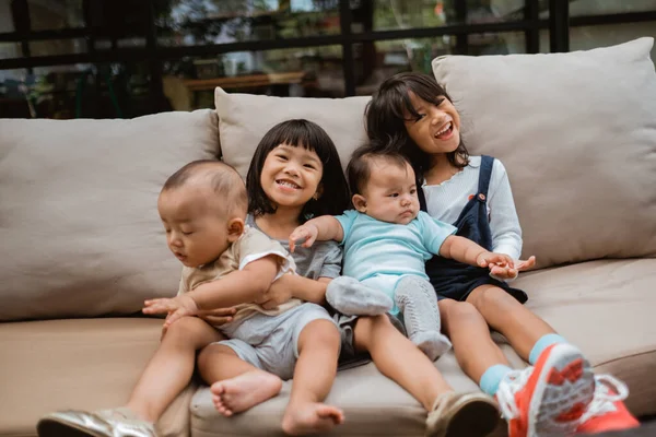 Азиатские дети улыбаются, сидя на кровати — стоковое фото
