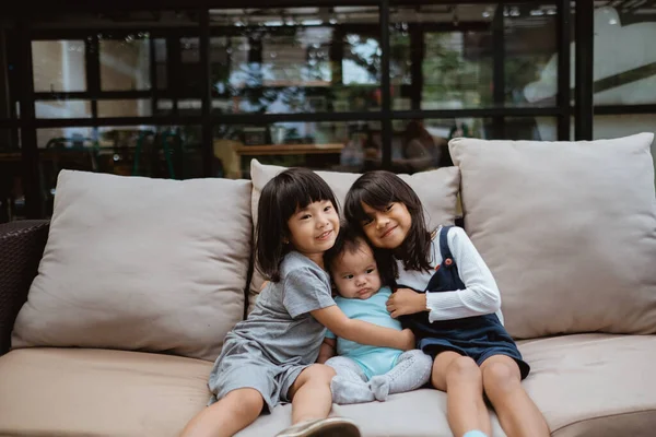 Азійські діти посміхаються, сидячи на ліжку. — стокове фото
