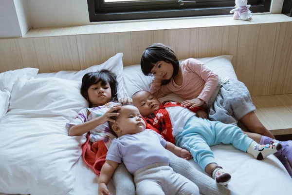 Čtyři děti si rády hrají a vtipkují v posteli — Stock fotografie