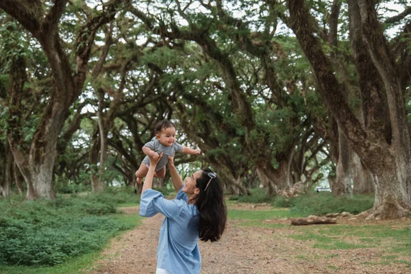 Mamma ride mentre sorregge un bambino — Foto Stock