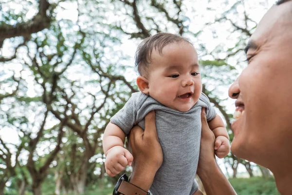 Papá se ríe mientras sostiene a un bebé — Foto de Stock