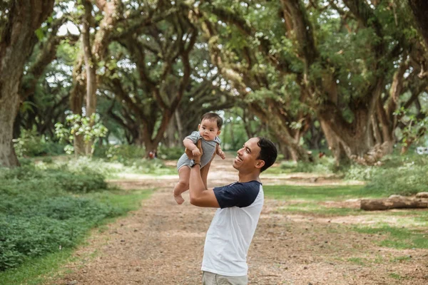 서 있는 동안 아기를 안고 있는 아버지 — 스톡 사진