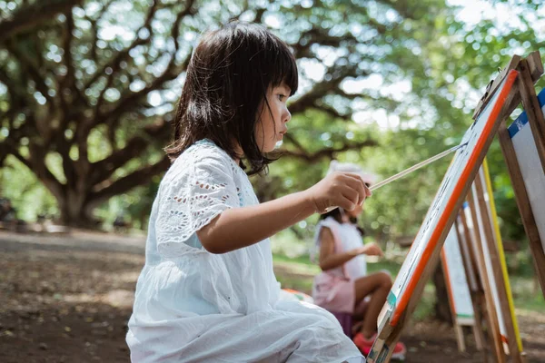 Азиатская маленькая девочка рисунок в саду — стоковое фото