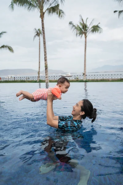 Asian mother picks up his daughters baby — Stock Photo, Image