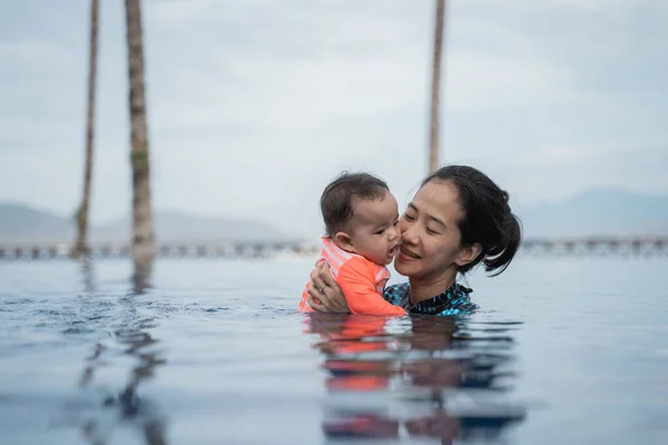 Madre tiene il suo bambino mentre impara a nuotare — Foto Stock