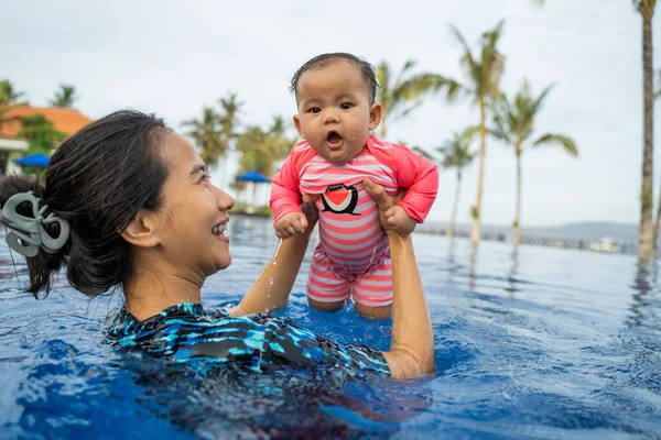 Asian mother picks up his daughters baby — Stock Photo, Image