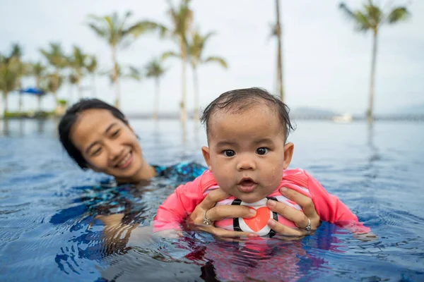 어머니는 수영을 배우면서 아기를 안 는다 — 스톡 사진