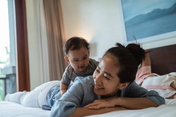 Азиатская мать лежит в постели со своей дочерью — стоковое фото