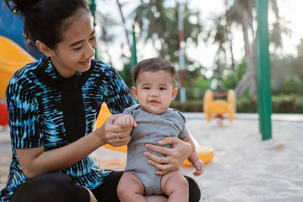 Asiático madre y poco hija disfrutar jugando en un parque infantil — Foto de Stock