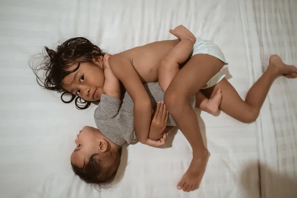 Asiático niño y poco hermana abrazando juntos cuando mentir —  Fotos de Stock