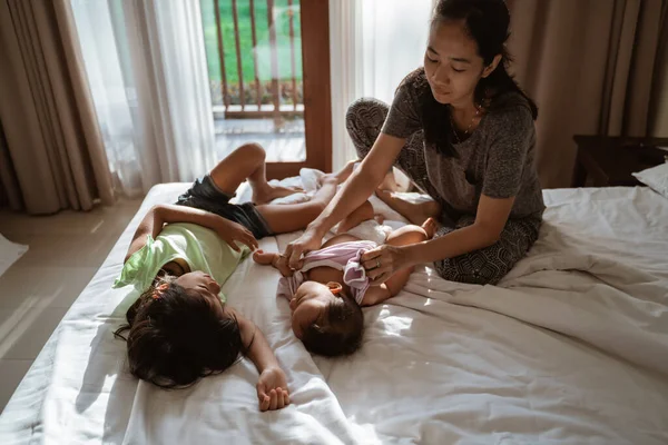 Asijské matka na sobě oblečení na jeho dítě — Stock fotografie