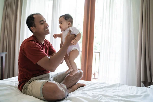 Asijský otec zvedne své dcery dítě — Stock fotografie