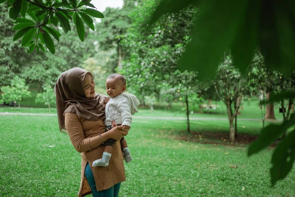 Wanita jilbab memegang bayi kecil — Stok Foto