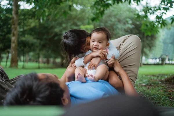 Due bambini rilassati seduti su uno stomaco di padri — Foto Stock