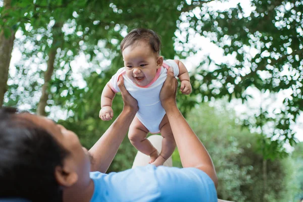 Pequeno bebê ri quando seu pai levantar — Fotografia de Stock