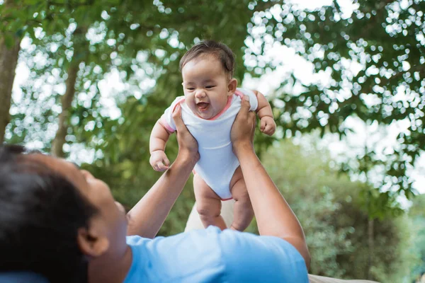 当他的父亲举起时，可爱的婴儿笑了 — 图库照片