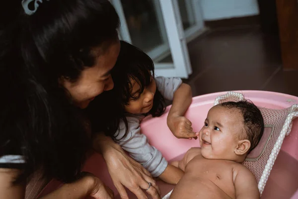 Entzückendes Baby beim Bad mit Mutter und Schwester — Stockfoto