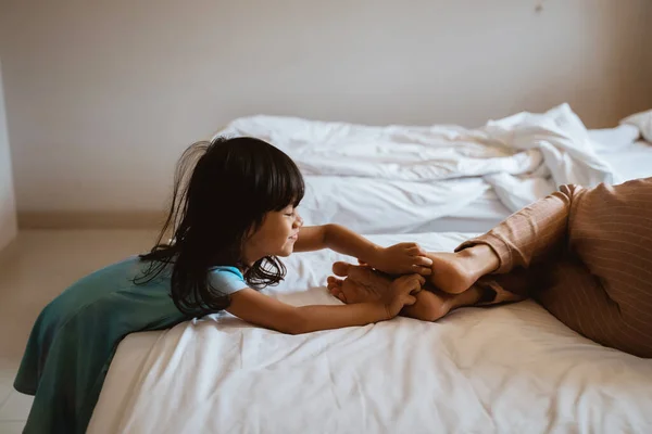 Niña está haciendo cosquillas en los pies de su madre — Foto de Stock