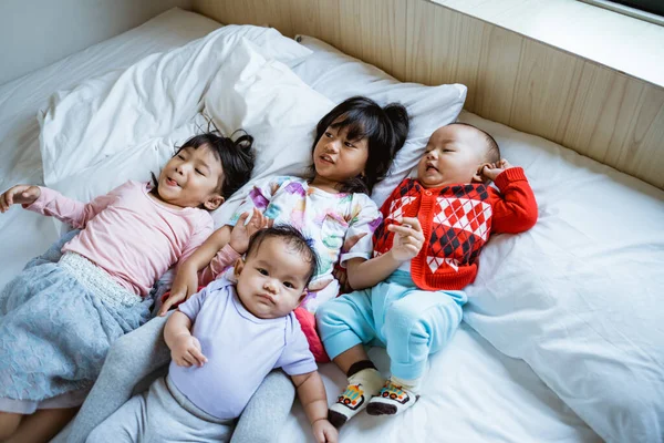 Quatro asiático crianças feliz para jogar e piada no cama — Fotografia de Stock