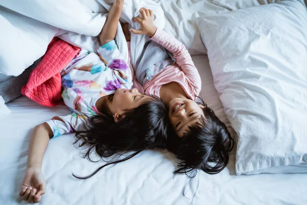 Dua gadis kecil bersenang-senang dan tertawa di tempat tidur — Stok Foto
