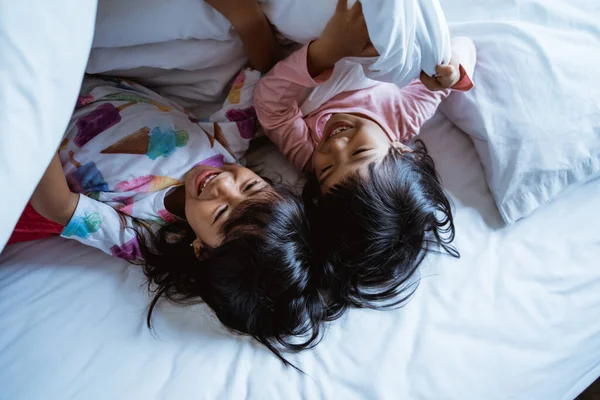 Dua gadis kecil bersenang-senang dan tertawa di tempat tidur — Stok Foto